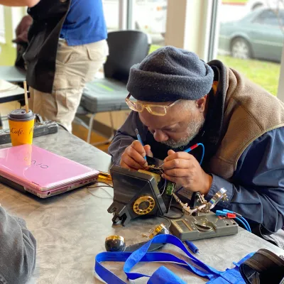 photo of someone repairing on old style telephone