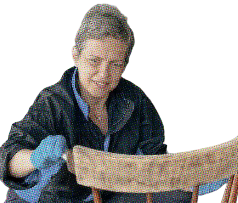 someone wearing a glove and repairing a chair